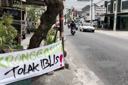 Baliho yang dipasang warga sebagai bentuk protes terkait pembangunan tempat hiburan malam di tanah kas desa Kronggahan. Sumber : Delima Purnamasari/Radar Jogja.