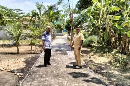 Kepala Desa Brumbungan Kidul Muji Ali (kiri) bersama Kepala Dusun Redu Rasuli mengecek pavingisasi jalan di RT 20/RW 3, Dusun Rambukoong. Sumber : Achmad Arianto/Jawa Pos Radar Bromo