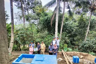Kades Wonomerto Siswoyo Kecamatan Wonosalam menyerahkan bantuan biogas dari DLH Jombang kepada warganya. Sumber : Anggi Fridianto/Radar Jombang
