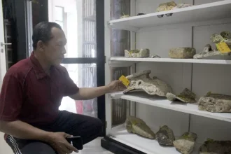Kepala Desa Telukawur Rokhman tunjukkan sejumlah temuan yang disimpan di balai desa setempat. Sumber : FIKRI THOHARUDIN/RADAR KUDUS