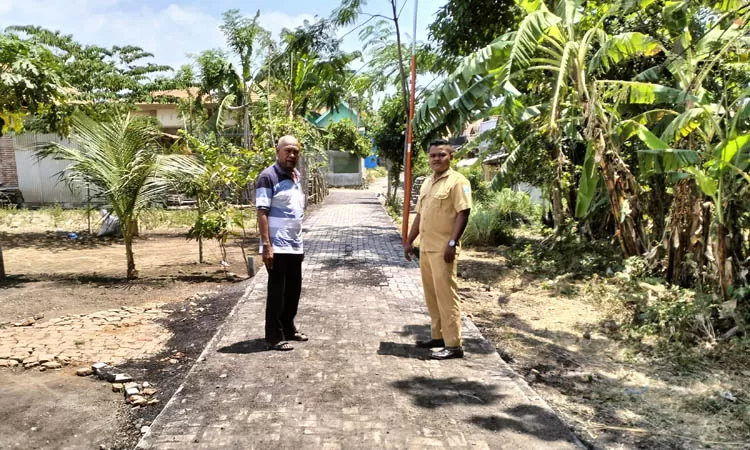 Kepala Desa Brumbungan Kidul Muji Ali (kiri) bersama Kepala Dusun Redu Rasuli mengecek pavingisasi jalan di RT 20/RW 3, Dusun Rambukoong. Sumber : Achmad Arianto/Jawa Pos Radar Bromo