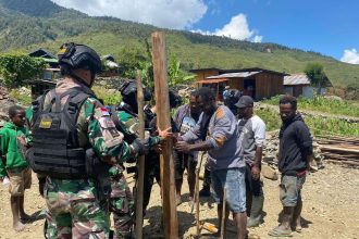 Satgas Pamtas Kewilayahan Yonif 753/AVT saat mendirikan satu tiang rumah.Sumber : rri.co.id