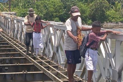 Anak SD melewati jembatan rusak di Ohoi (Desa) Dian Darat, Kabupaten Maluku Tenggara. Sumber : TribunAmbon.com