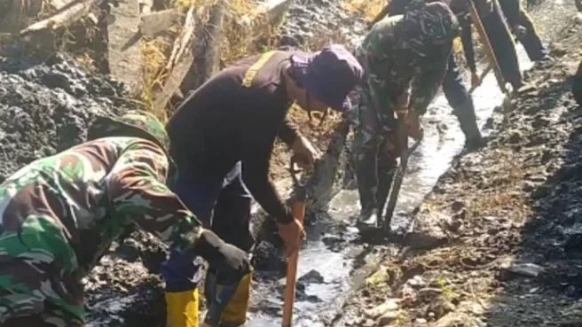 TNI dan warga membersihkan saluran irigasi menuju ke ladang sawah di Desa Dongi. Sumber: global.katasulsel.com.