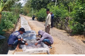 Sekdes Patokan Soleh Hudin (bediri), meninjau langsung proses pembangunan drainase di Dusun Krajan. Sumber : Arif Mashudi/Jawa Pos Radar Bromo