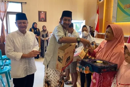 Kepala Desa Kepatihan Erwin Pribadi didampingi Camat Jombang Heri Prayitno, saat menyerahkan bantuan kompor kepada warga,. Sumber : Anggi Fridianto/Radar Jombang