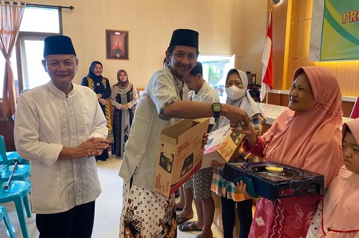 Kepala Desa Kepatihan Erwin Pribadi didampingi Camat Jombang Heri Prayitno, saat menyerahkan bantuan kompor kepada warga,. Sumber : Anggi Fridianto/Radar Jombang