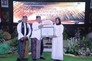 Pj Bupati Jombang Teguh Narutomo secara langsung menyerahkan sertifikat penghargaan kepada Kepala Desa Jatirejo Arifah di acara Gebyar PBB-P2 di Pendopo Kabupaten Jombang. Sumber : Desakita.co