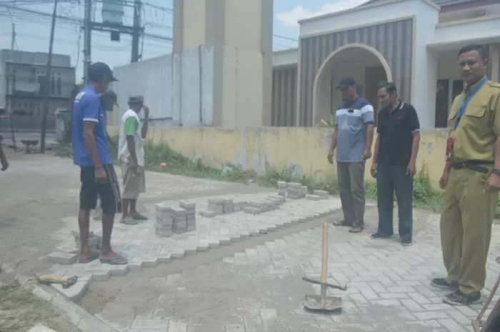 Kades Peterongan Ali Muzaki (bertopi) bersama perangkat desa dan Ketua TPK desa melakukan pengecekan pembangunan paving di Dusun Wonokerto. Sumber : Ainul Hafidz/RadarJombang