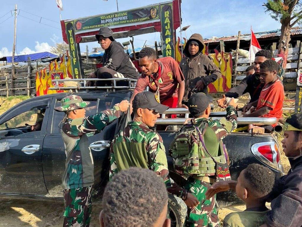 Prajurit Satgas Yonif 614/Raja Pandita saat membagikan makanan kepada masyarakat Popome. Sumber : rri.co.id