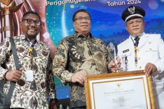 Kepala Desa Oba Sabtu Kenne dan Sekertaris Daerah Kota Tidore Ismail Dukomalamo saat menerima penghargaan dari Kemendagri. Sumber : rri.co.id