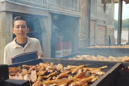Kades Rantau Bayur Heru Julian, saat menunjukan produksi ikan yang akan dibuat ikan asin dan ikan salai. Sumber: sripoku.com