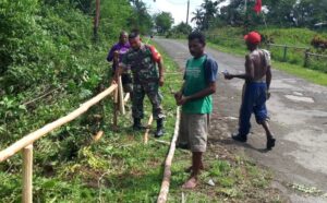 Warga Kampung Kababur bersama Babinsa gotong-royong membuat pagar jalan. Sumber : liranews.com