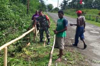 Warga Kampung Kababur bersama Babinsa gotong-royong membuat pagar jalan. Sumber : liranews.com
