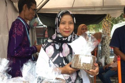 Ketua Badan Usaha Milik Desa (BUM Desa) Lestari, Asniar memamerkan produk hasil olahan limbah kelapa. Sumber: palu.tribunnews.com.