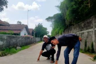 Kepala Desa Rejoagung Ahmad Kasani bersama Ahmad Marzuki PPK Desa Rejoagung menunjukan Jalan alternatif Jombang-Kediri menjadi mulus setelah dibangun Pemdes Rejoagung, Kecamatan Ngoro Jombang. Sumber : Azmy Endiyana Z/Radar Jombang