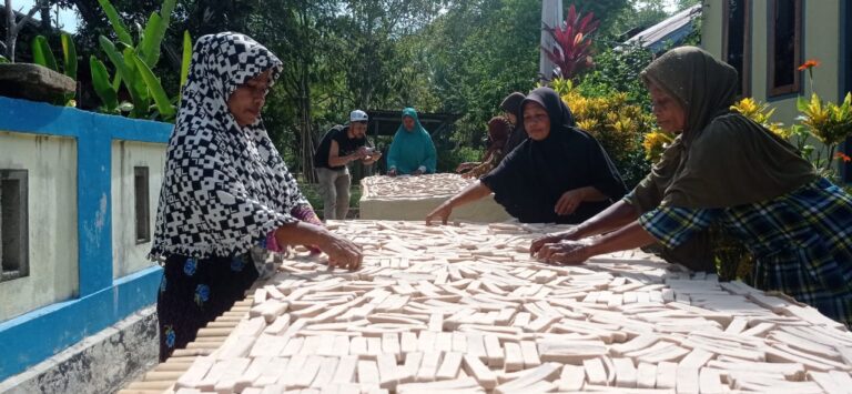 Ibu-ibu di Desa Kilfura sedang menjemur sagu lempeng di halaman rumah. Sumber: dokumentasi TEKAD