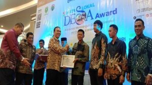 Penyerahan penghargaan Mata Lokal Desa Award, kepada Kades Lesung Batu Radius Prawira. Sumber: tribunsumsel.com