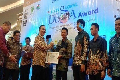 Penyerahan penghargaan Mata Lokal Desa Award, kepada Kades Lesung Batu Radius Prawira. Sumber: tribunsumsel.com