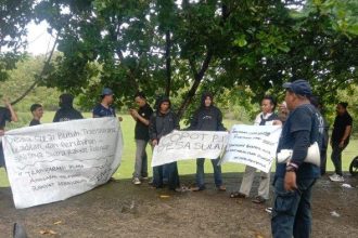 Aksi damai yang dilakuan oleh pemuda di depan Kantor Desa Sulai. Sumber: Tribunsulbar.com