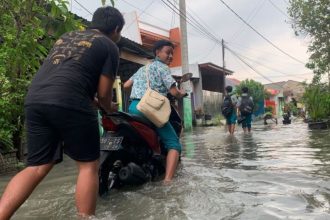 Fahmi Alfian saat terkenak banjir. Sumber foto : AntaraJatim