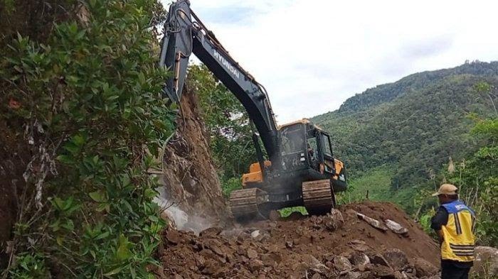 Proses pembersihan material longsor jalan penghubung empat desa di Kabupaten Mamuju. Sumber: TribunSulbar.com