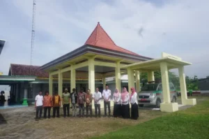 Kepala Desa Bugasurkedaleman Surawi didampingi jajaran perangkat dan warga masyarakat di depan pendopo kantor desa. Sumber: Radar Jombang