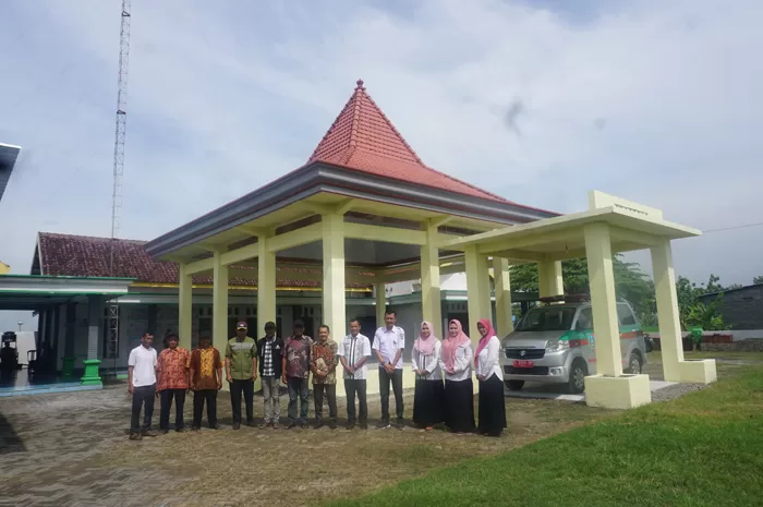 Kepala Desa Bugasurkedaleman Surawi didampingi jajaran perangkat dan warga masyarakat di depan pendopo kantor desa. Sumber: Radar Jombang